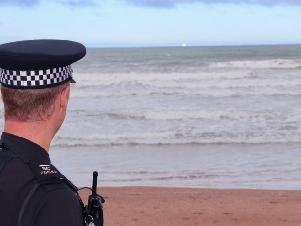 A police officer looking out to sea