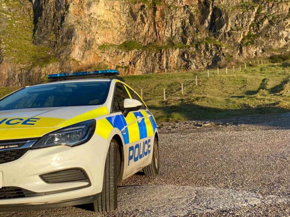 A police car parked in a coastal car park